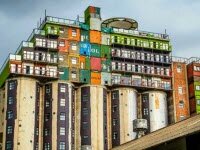 Бункеры увенчанной стопками контейнеров, представляют недорогое студенческое жилье